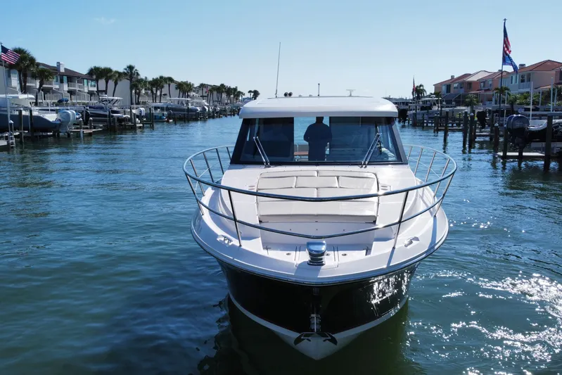  Yacht Photos Pics 2022 Regal 38 XO yacht cruising in a sunny marina with waterfront homes.