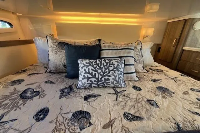  Yacht Photos Pics Luxurious 2022 Regal 38 XO yacht cabin with elegant bedding and ambient lighting.