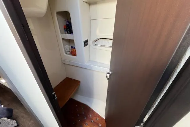  Yacht Photos Pics 2022 Regal 38 XO yacht interior bathroom with wooden accents and storage shelves.