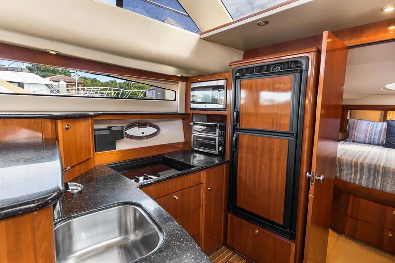 Bella Vita Yacht Photos Pics Luxurious 2008 Meridian 408 Motoryacht kitchen with wood cabinetry and modern appliances.