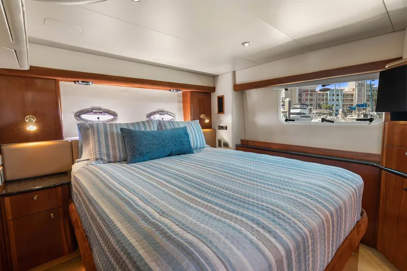 Bella Vita Yacht Photos Pics Luxurious bedroom interior of 2008 Meridian 408 Motoryacht with striped bedding and porthole views.