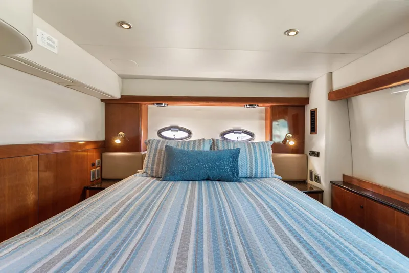 Bella Vita Yacht Photos Pics Luxurious bedroom interior of 2008 Meridian 408 Motoryacht with striped bedding and wood accents.