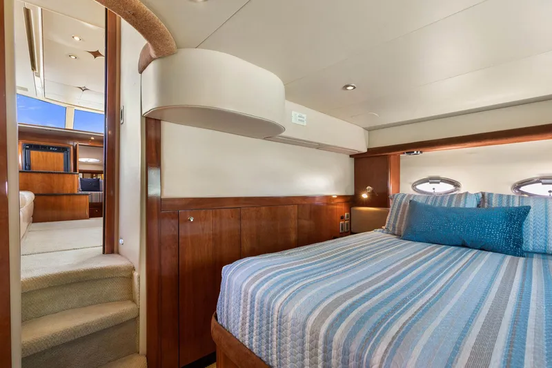 Bella Vita Yacht Photos Pics Luxurious bedroom interior of 2008 Meridian 408 Motoryacht with striped bedding and wood accents.