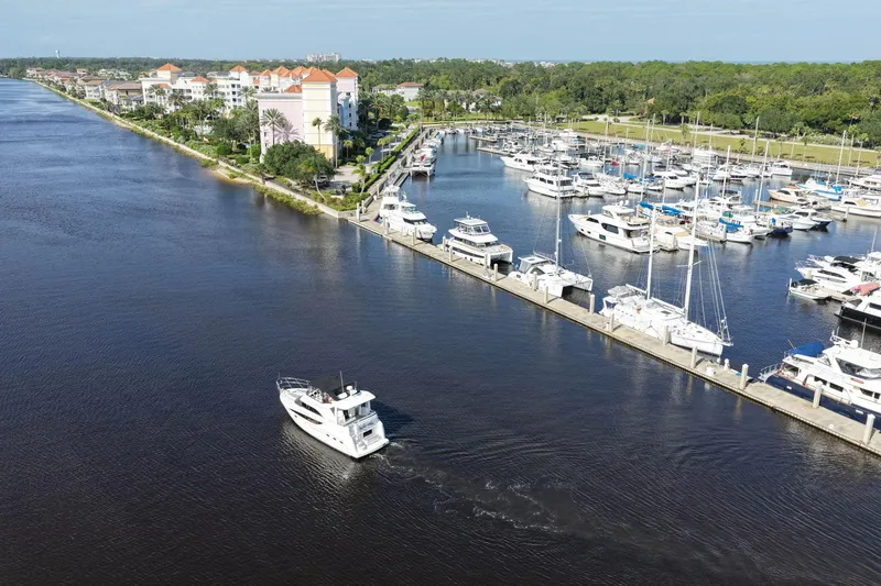 Bella Vita Yacht Photos Pics Aerial view of 2008 Meridian 408 Motoryacht cruising near marina with docked boats.