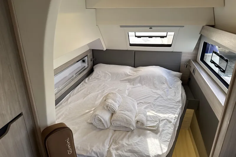 Alter Ego Yacht Photos Pics Luxurious bedroom in 2023 Catana 50 Ocean Class yacht with cozy bedding and windows.