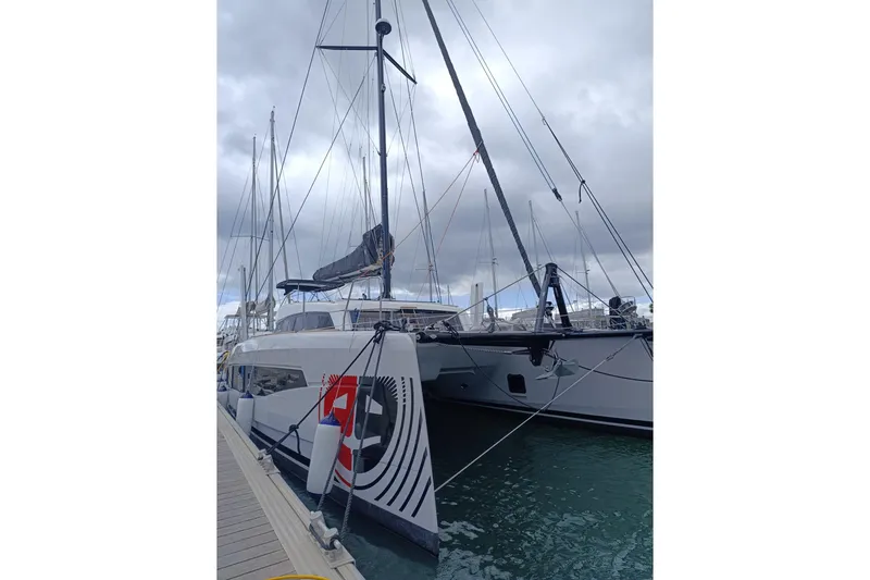 Alter Ego Yacht Photos Pics 2023 Catana 52 Ocean Class catamaran docked at marina under cloudy sky.