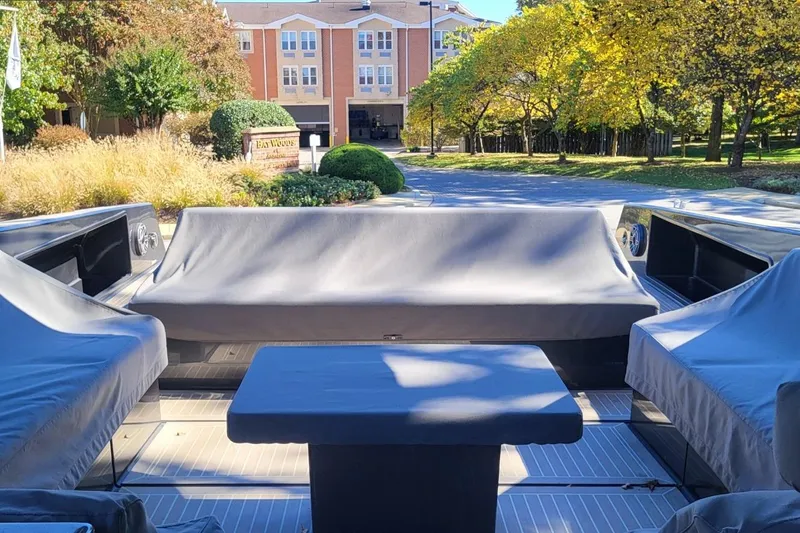  Yacht Photos Pics 2023 VanDutch 56 yacht interior with covered seating, surrounded by autumn trees and residential buildings.