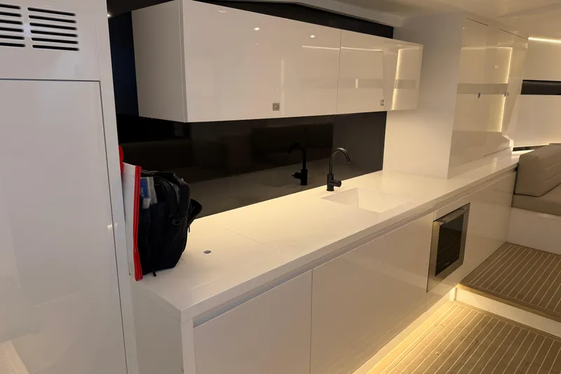  Yacht Photos Pics Luxurious interior of 2023 VanDutch 56 yacht with sleek white cabinetry and modern fixtures.