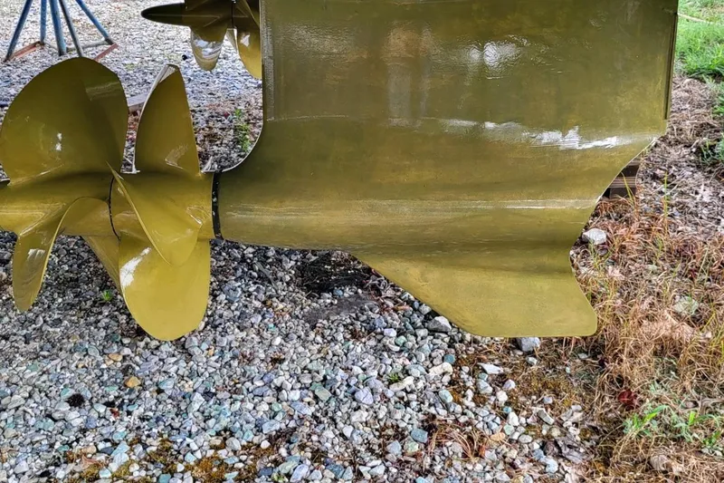  Yacht Photos Pics Propeller and rudder of 2023 VanDutch 56 yacht on gravel surface.