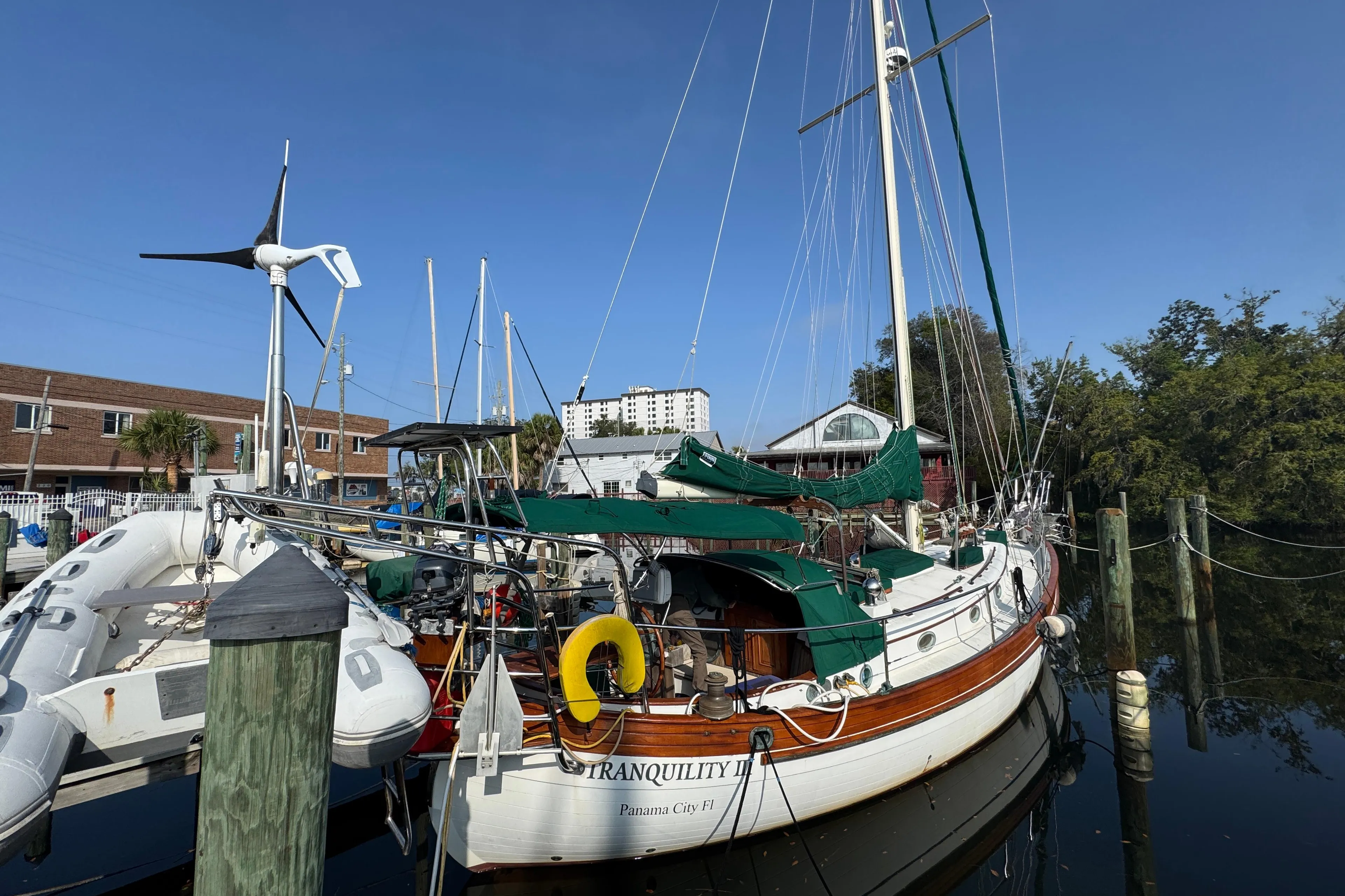 Sailboat "Tranquility" docked, Hans Christian 43T, 1989 model, with green covers and wind turbine.