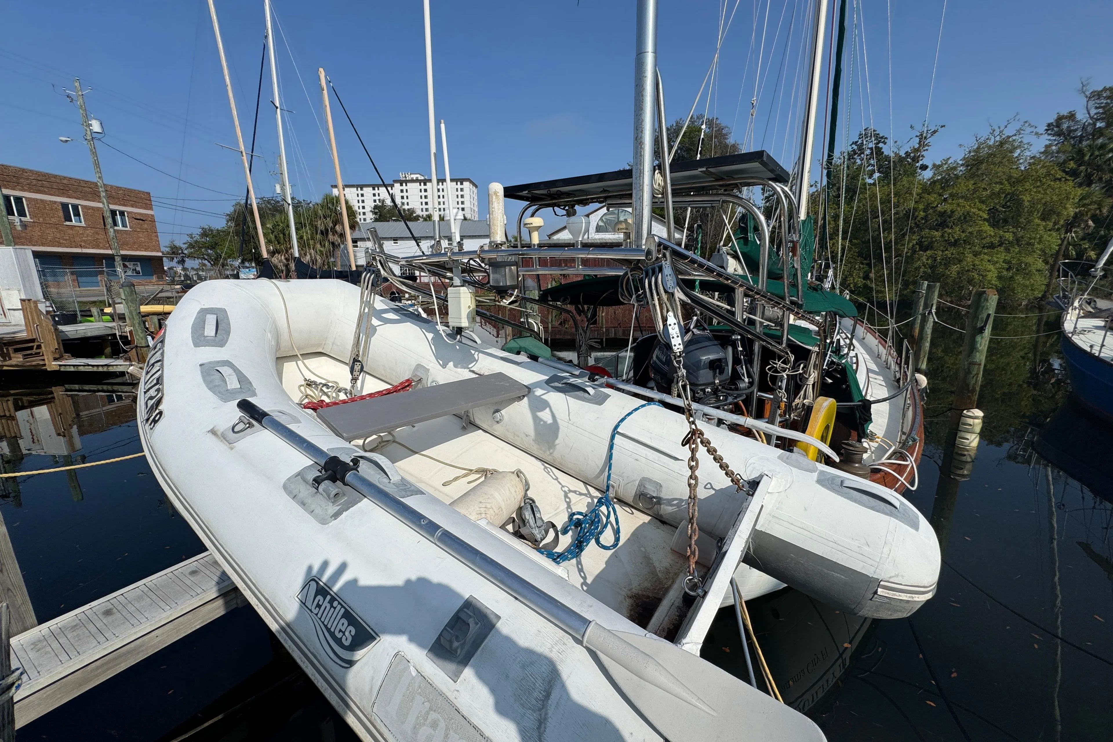 Sailboat Hans Christian 43T (1989) docked with inflatable dinghy in marina.