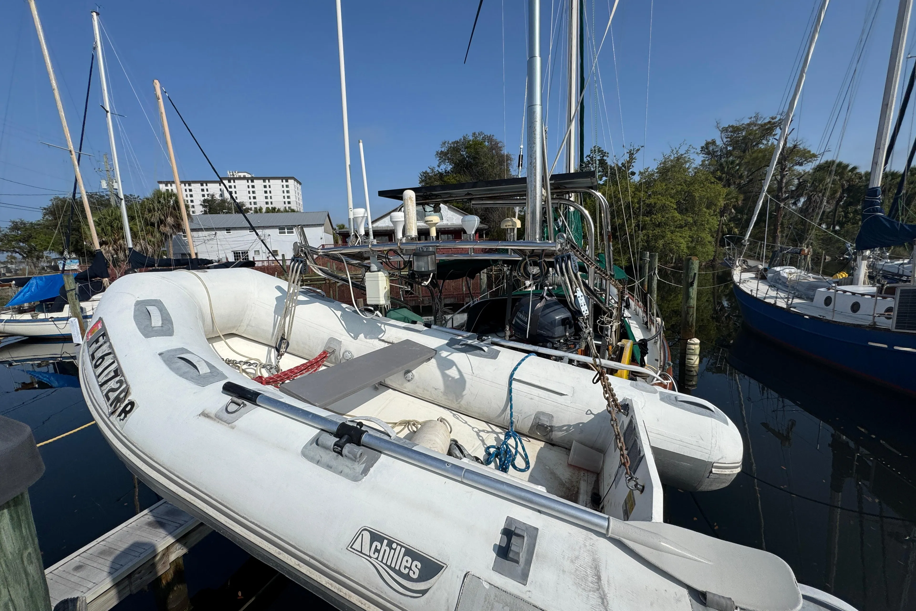 Sailboat docked with inflatable dinghy, Hans Christian 43T, 1989 model, in a marina setting.