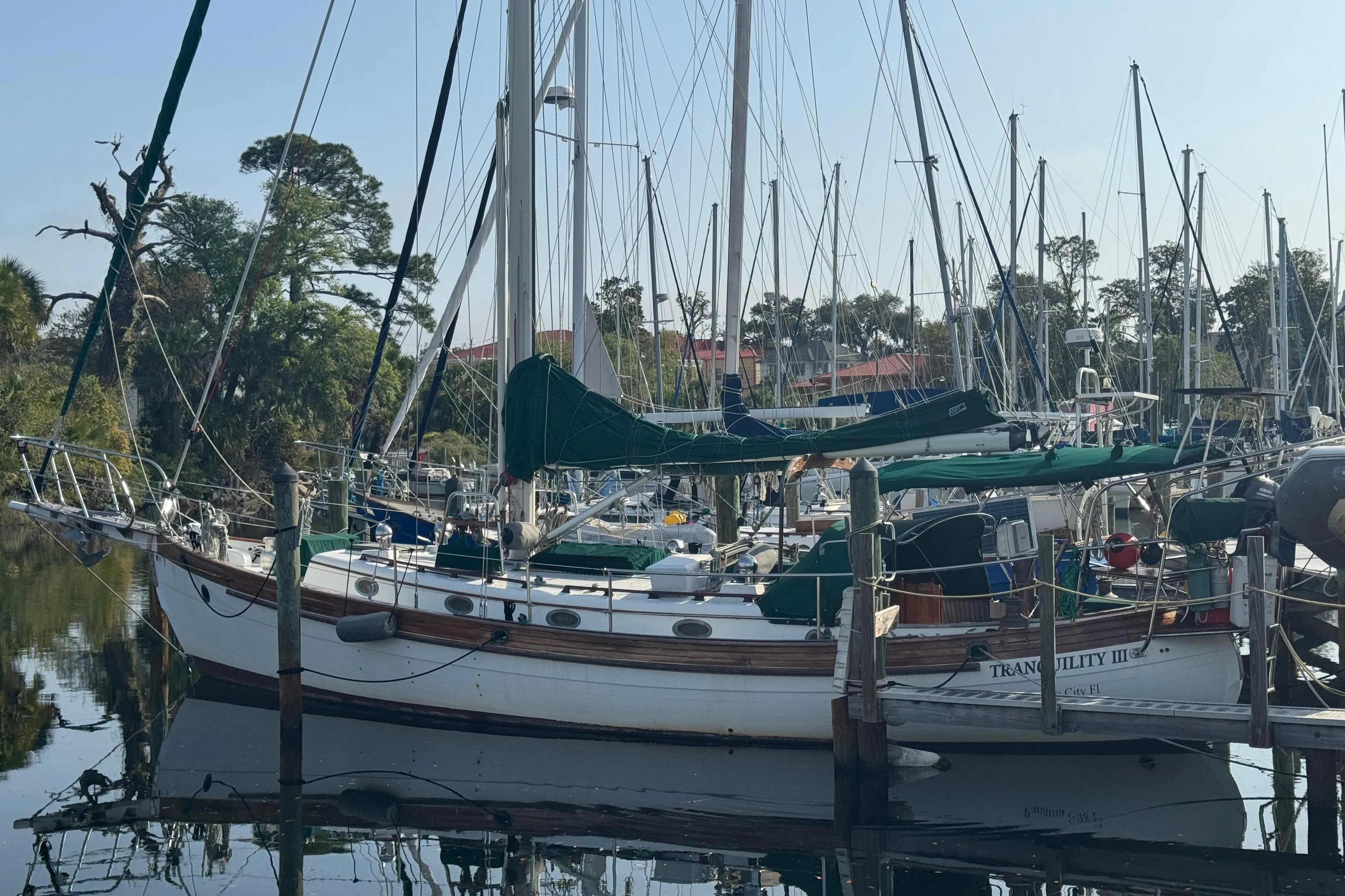 1989 Hans Christian 43T sailboat docked in a marina, surrounded by other boats.