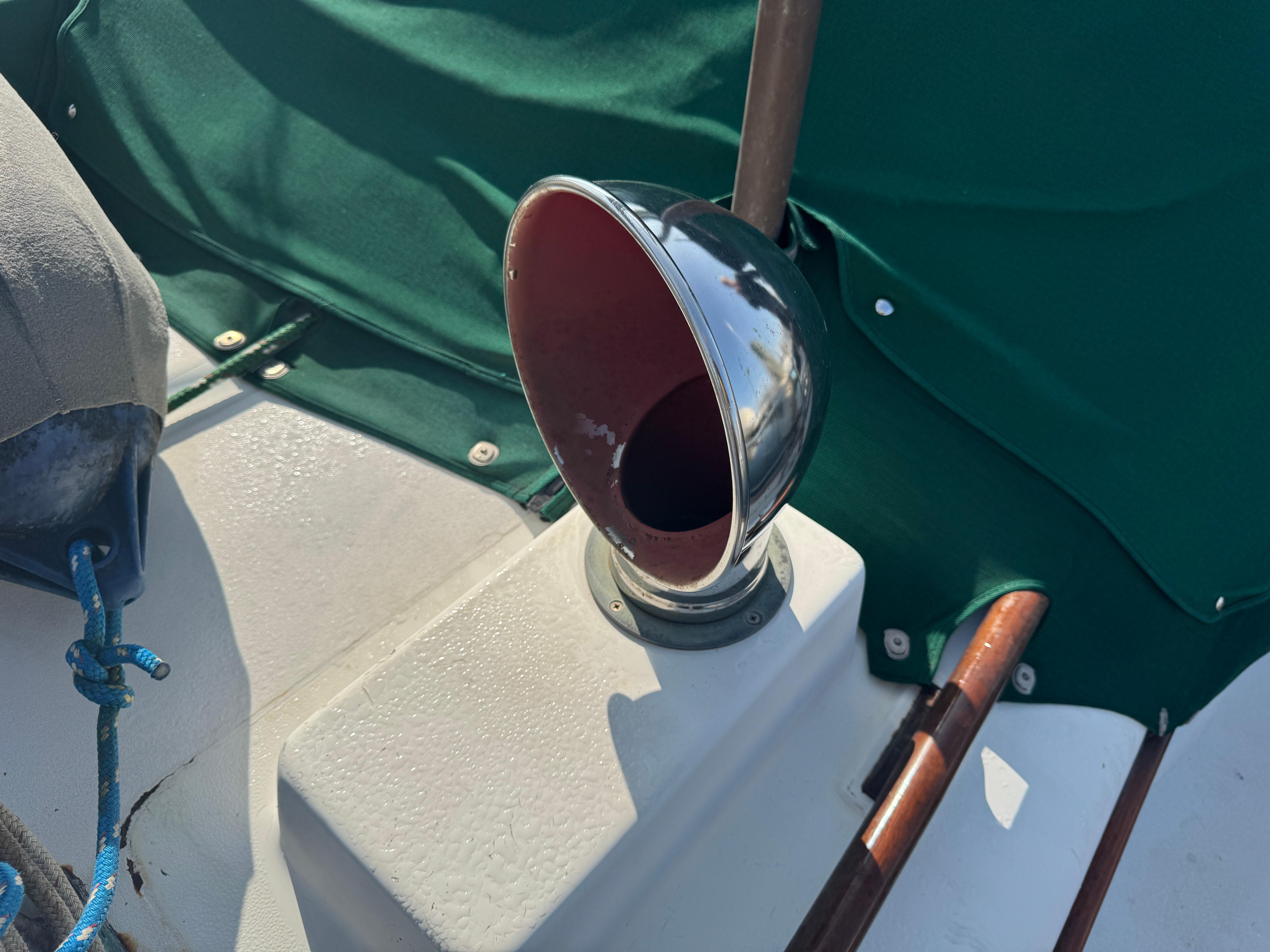 1989 Hans Christian 43T sailboat deck with chrome vent and green canvas cover.