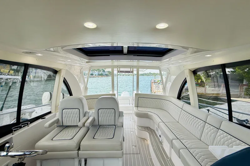  Yacht Photos Pics Luxurious interior of 2021 Intrepid 410 Evolution yacht with plush seating and panoramic windows.