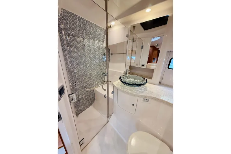 Yacht Photos Pics Luxurious bathroom in 2021 Intrepid 410 Evolution yacht with glass sink and modern shower.