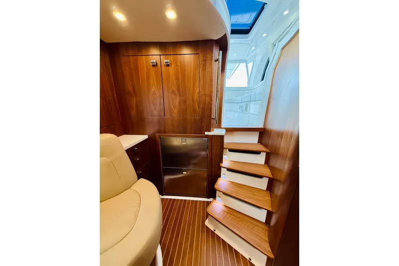  Yacht Photos Pics Luxurious interior of 2021 Intrepid 410 Evolution yacht with wooden stairs and seating.