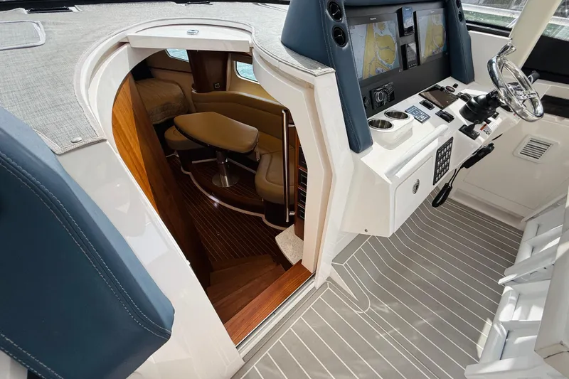  Yacht Photos Pics 2021 Intrepid 410 Evolution yacht interior with helm, navigation screens, and cabin entrance.