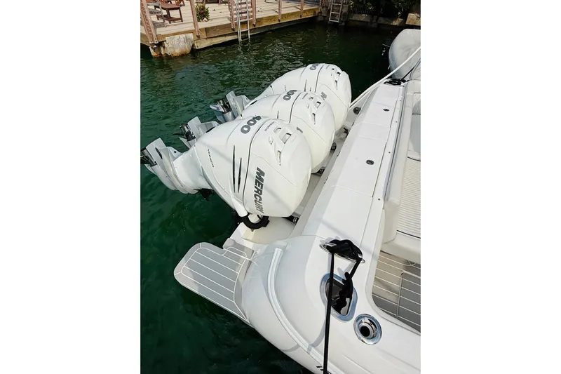  Yacht Photos Pics 2021 Intrepid 410 Evolution with triple Mercury outboard engines docked by the water.