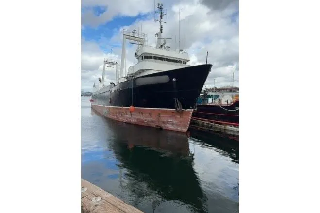  Yacht Photos Pics 1976 Halter Custom Built Mid-Water Trawler docked, reflecting on calm water under cloudy sky.