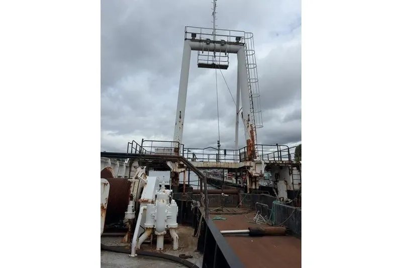  Yacht Photos Pics 1976 Halter Custom Built Mid-Water Trawler deck with fishing equipment under cloudy sky.