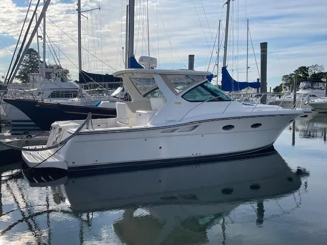 Mae Yacht Photos Pics 2005 Tiara Yachts 3200 in marina, sleek design, calm water reflection.