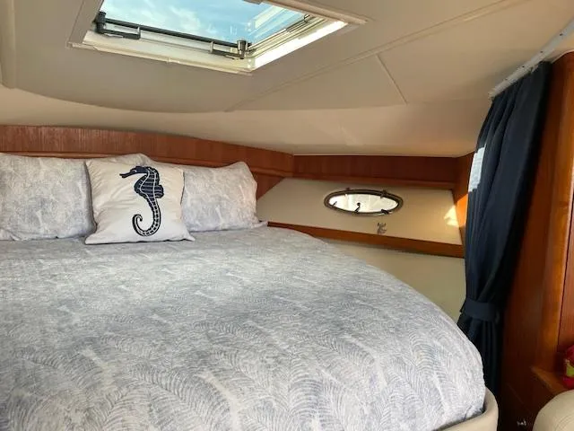 Mae Yacht Photos Pics 2005 Tiara Yachts 3200 cabin interior with skylight, seahorse pillow, and elegant bedding.