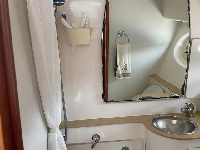 Mae Yacht Photos Pics Bathroom interior of 2005 Tiara Yachts 3200, featuring sink, mirror, and shower area.