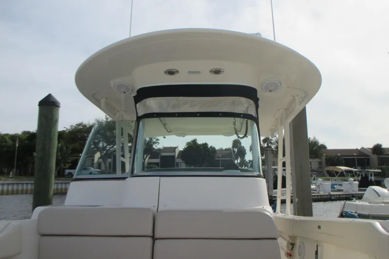  Yacht Photos Pics 2013 Pursuit ST 310 Sport boat docked, showcasing helm and seating area.