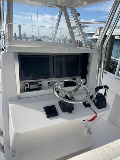 Yacht Photos Pics Control panel of a 2013 Bahama 41 Open boat with steering wheel and navigation screens.
