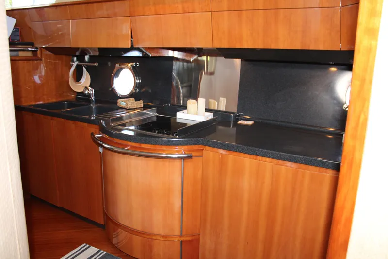  Yacht Photos Pics Luxurious kitchen interior of a 2006 Azimut 50 yacht with wood cabinetry and sleek countertops.