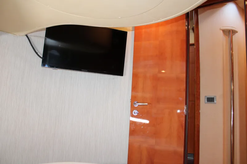  Yacht Photos Pics Interior of 2006 Azimut 50 yacht with wall-mounted TV and wooden door.