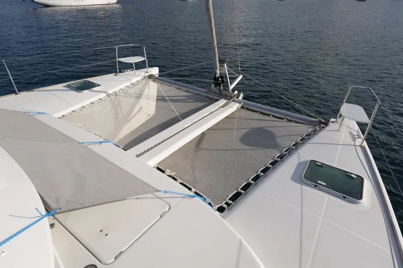 Sillage Yacht Photos Pics Catamaran Lagoon 380 (2002) with netting on deck, anchored on calm water.
