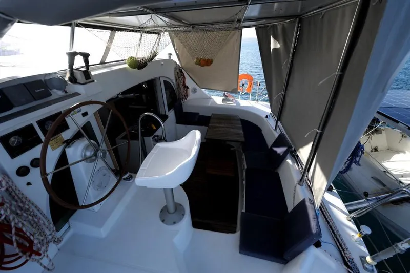 Sillage Yacht Photos Pics Interior view of 2002 Lagoon 380 catamaran cockpit with seating and steering wheel.