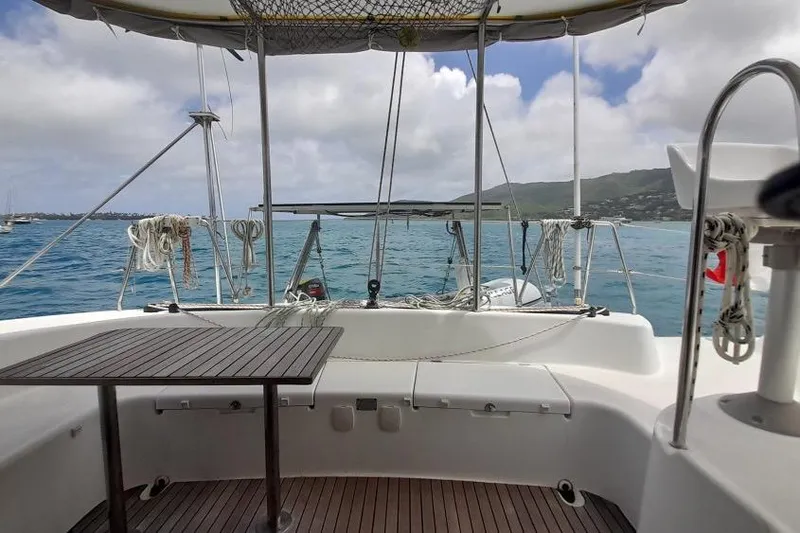 Sillage Yacht Photos Pics Lagoon 380 catamaran deck view, 2002 model, overlooking serene ocean and distant coastline.