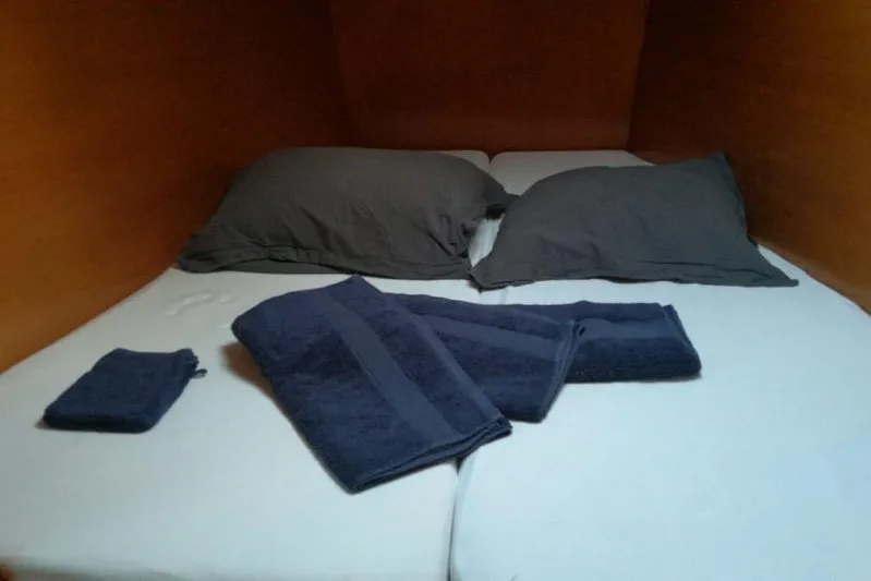 Sillage Yacht Photos Pics Cozy cabin bed with dark pillows and towels on Lagoon 380, 2002 model.