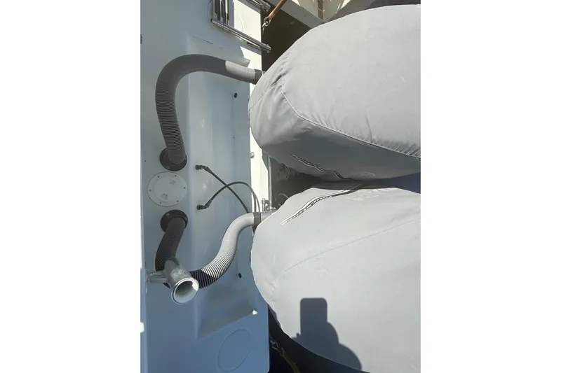  Yacht Photos Pics 2003 Contender 27 Open boat with covered engines and visible hoses.