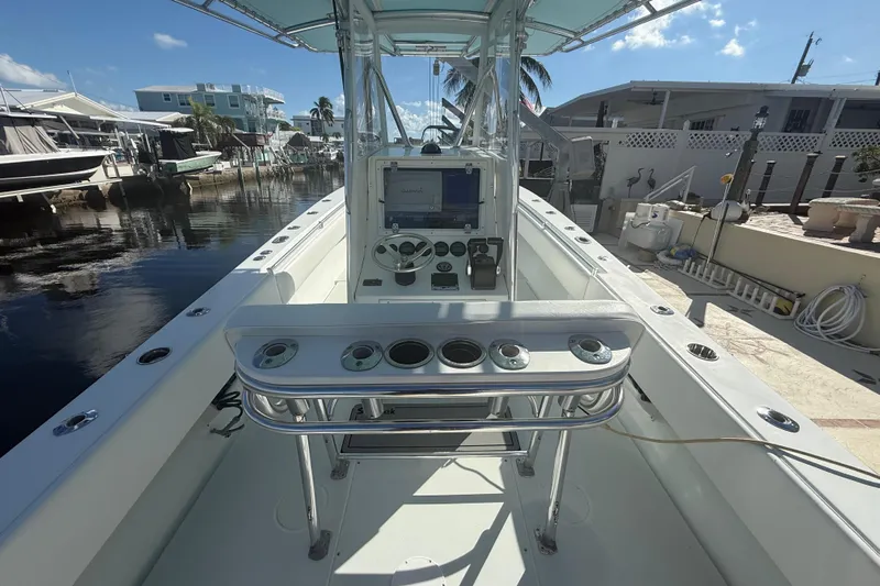  Yacht Photos Pics 2003 Contender 27 Open boat interior with console and rod holders, docked by waterfront homes.