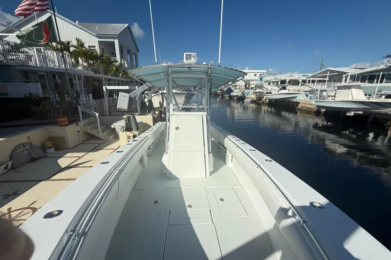  Yacht Photos Pics 2003 Contender 27 Open boat docked in a sunny marina, surrounded by waterfront homes.