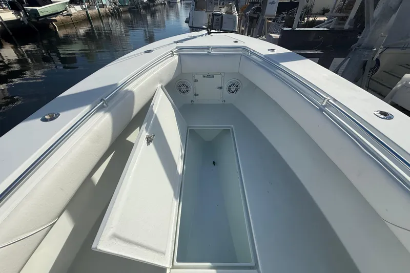  Yacht Photos Pics 2003 Contender 27 Open boat interior with open storage compartment, docked at marina.