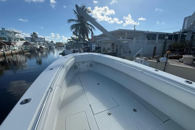  Yacht Photos Pics 2003 Contender 27 Open boat docked in a scenic canal with palm trees.