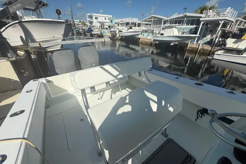  Yacht Photos Pics 2003 Contender 27 Open boat docked at marina, featuring spacious seating and calm waters.