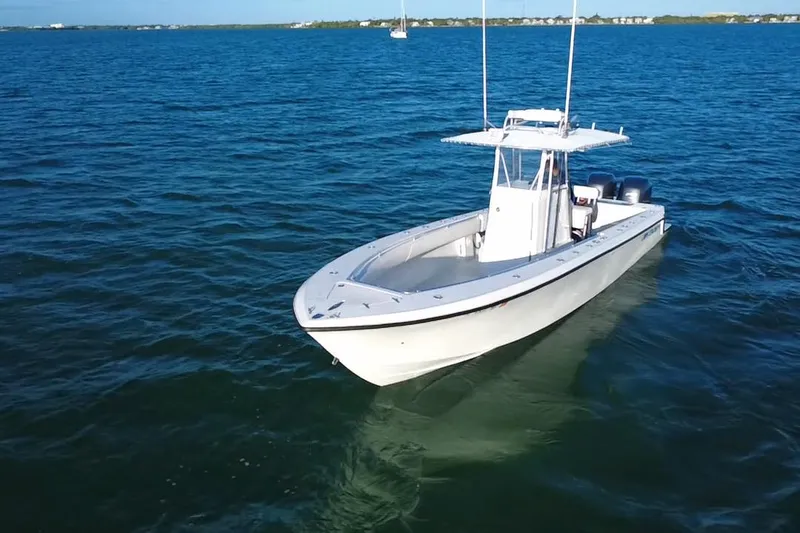  Yacht Photos Pics 2003 Contender 27 Open boat on calm blue waters, showcasing sleek design and twin engines.