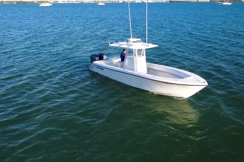  Yacht Photos Pics 2003 Contender 27 Open boat on calm blue water, distant shoreline visible.