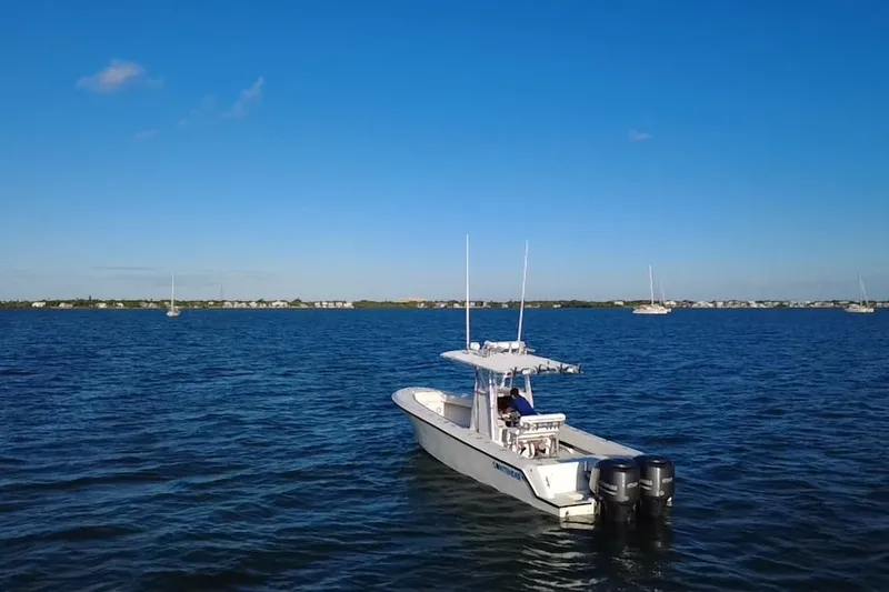  Yacht Photos Pics 2003 Contender 27 Open boat on calm blue water under clear sky.
