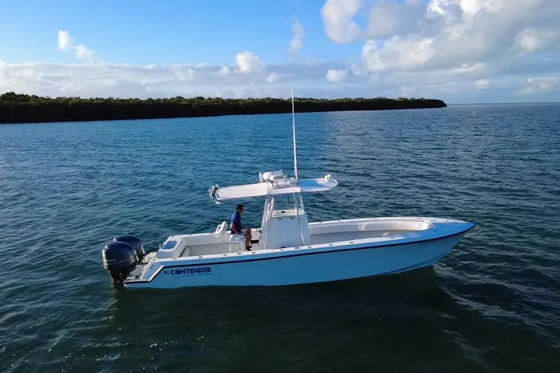  Yacht Photos Pics 2003 Contender 27 Open boat on calm water under a partly cloudy sky.