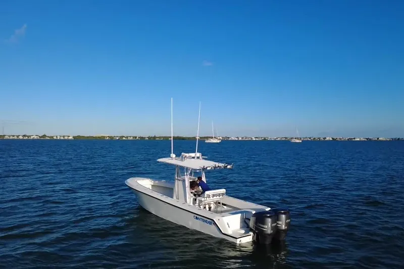  Yacht Photos Pics 2003 Contender 27 Open boat on calm blue waters under clear sky.