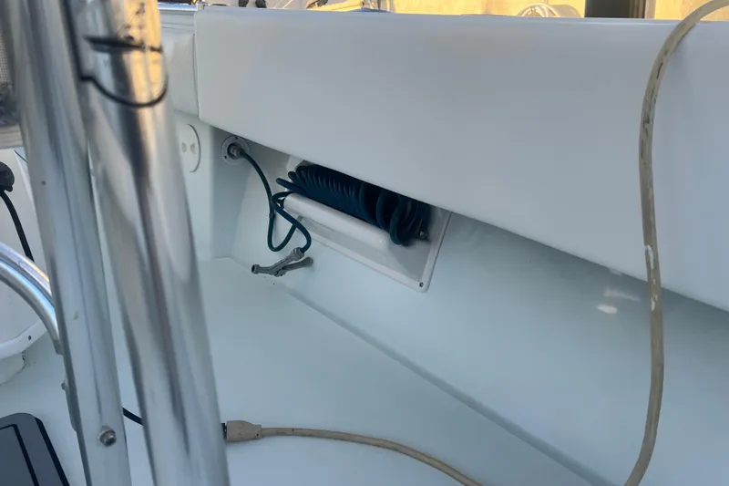  Yacht Photos Pics 2003 Contender 27 Open boat interior with coiled blue hose and metal railing.