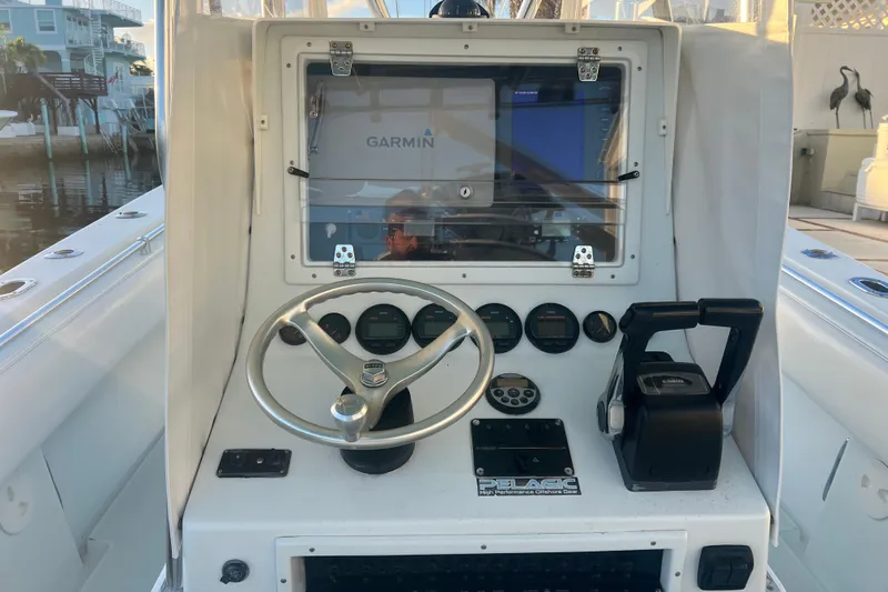  Yacht Photos Pics 2003 Contender 27 Open boat console with Garmin navigation system and steering wheel.
