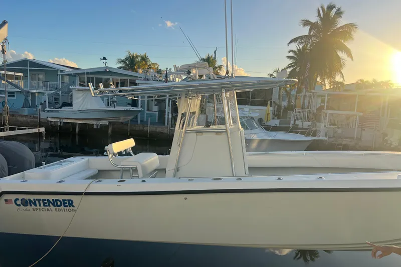  Yacht Photos Pics 2003 Contender 27 Open boat docked at sunset, featuring sleek design and palm trees in the background.